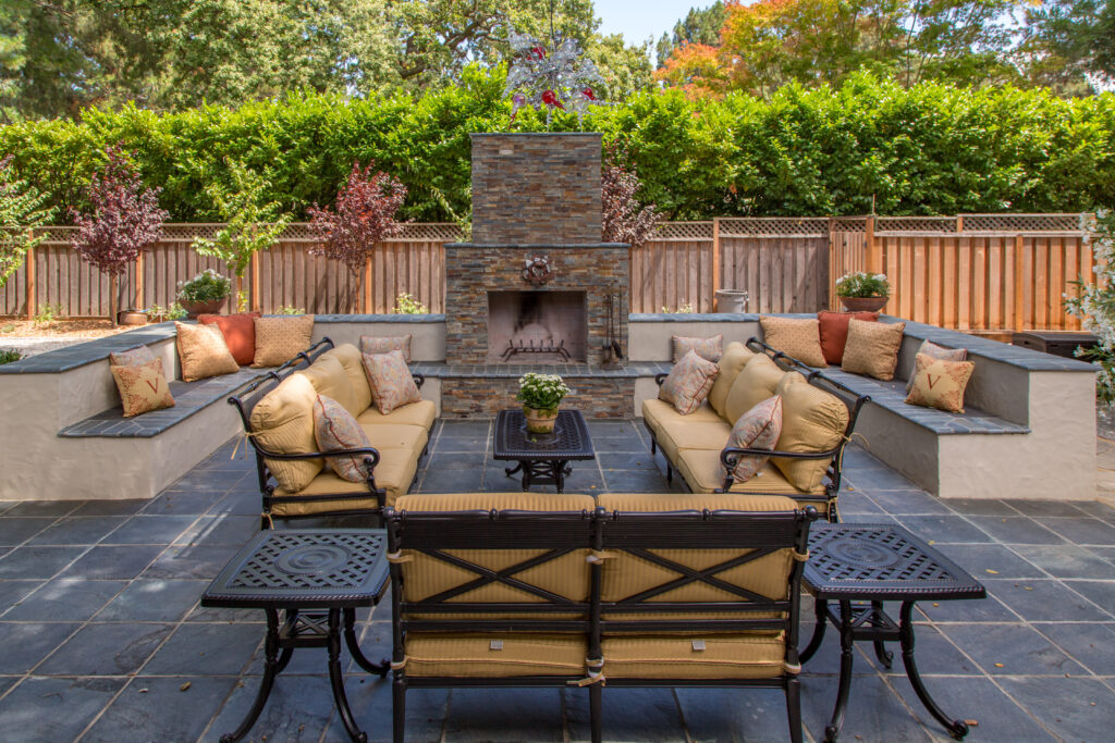Modern backyard patio with porcelain pavers, built-in fire pit, and lounge seating – patio ideas